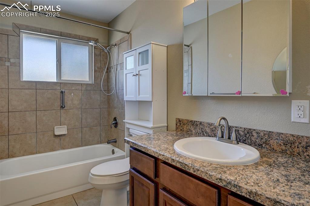 Image 23 of 33: Bathroom featuring shower / bath combination, vanity, and tile patterned fl