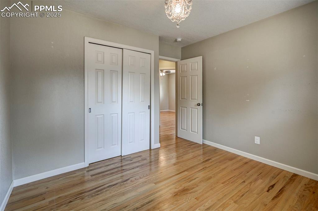 Image 24 of 33: Unfurnished bedroom with light wood finished floors and a closet