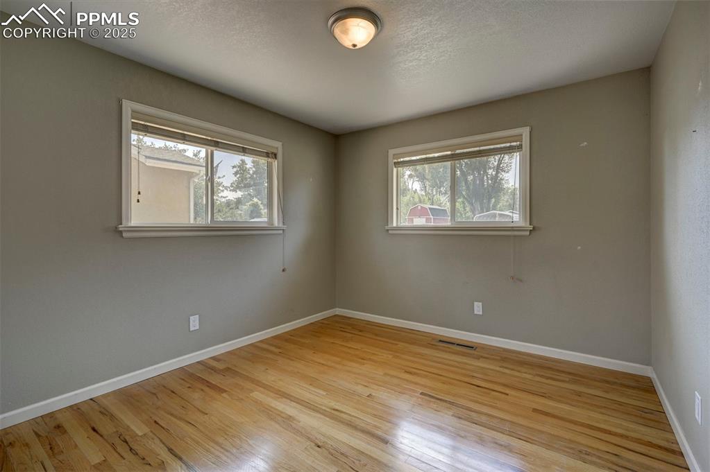 Image 25 of 33: Unfurnished room with light wood finished floors, plenty of natural light, 