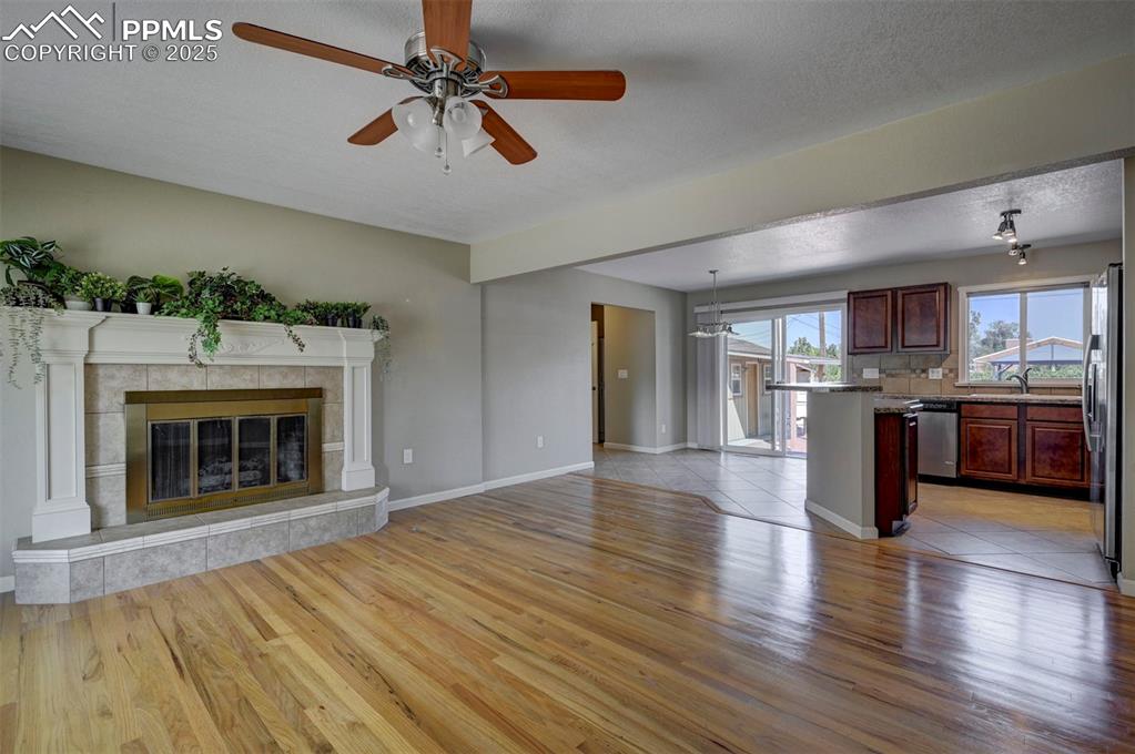 Image 5 of 33: living room , ceiling fan, wood-flooring, and a gas fireplace