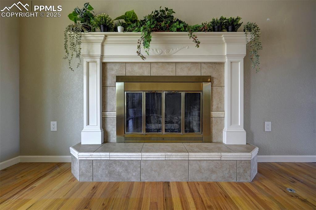 Image 8 of 33: Detailed view of wood finished floors and a tile fireplace