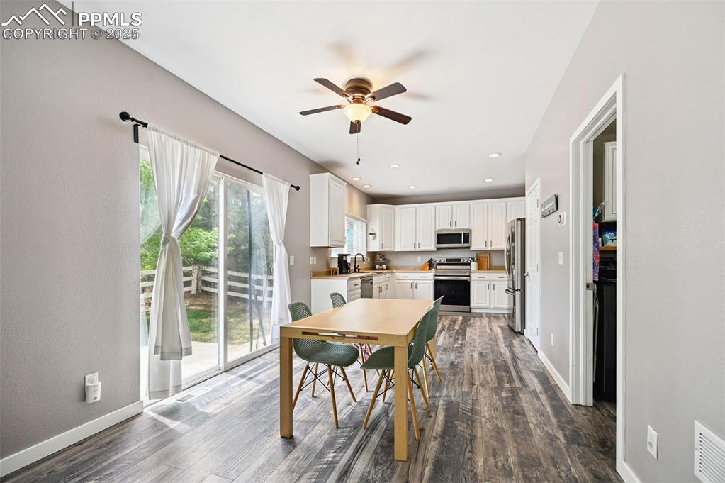 Image 12 of 29: Dining room featuring recessed lighting, dark wood-style floors, ceiling fa