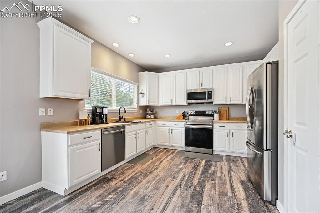 Image 13 of 29: Kitchen with appliances with stainless steel finishes, recessed lighting, d