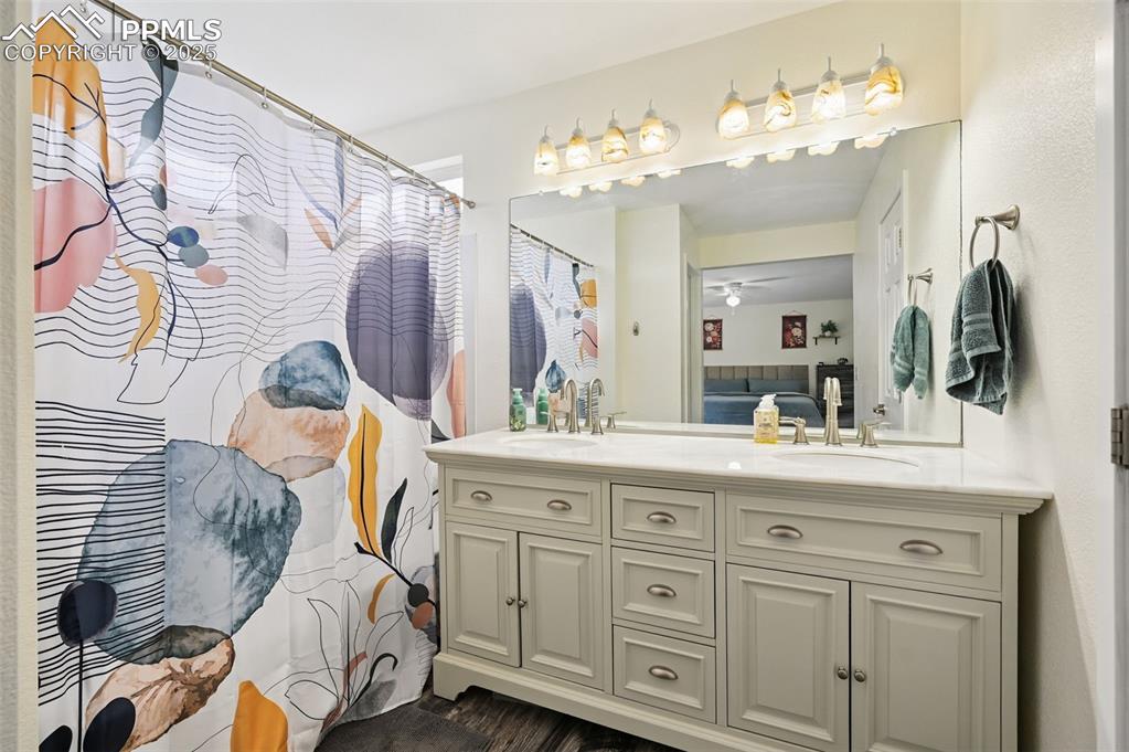 Image 21 of 29: Full bath with double vanity, ensuite bath, a shower with curtain, and a ce