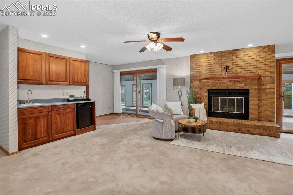 Image 19 of 30: Wet bar, fireplace, & pool access
