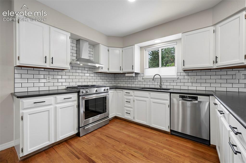 Image 8 of 50: Kitchen with new backsplash and vent hood