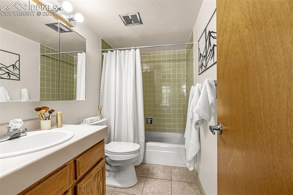 Image 18 of 24: Tub/shower combo with tile accent