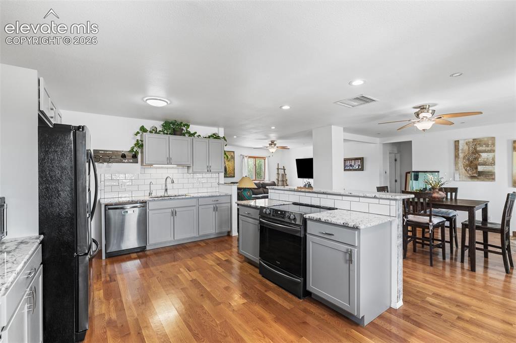 Image 6 of 41: Updated kitchen with granite counter tops, bar seating, black stainless app