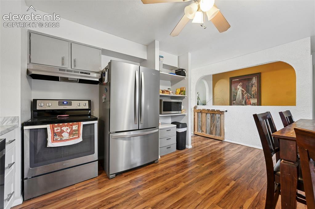 Image 11 of 33: Kitchen featuring stainless steel appliances, wood-finish flooring, white c