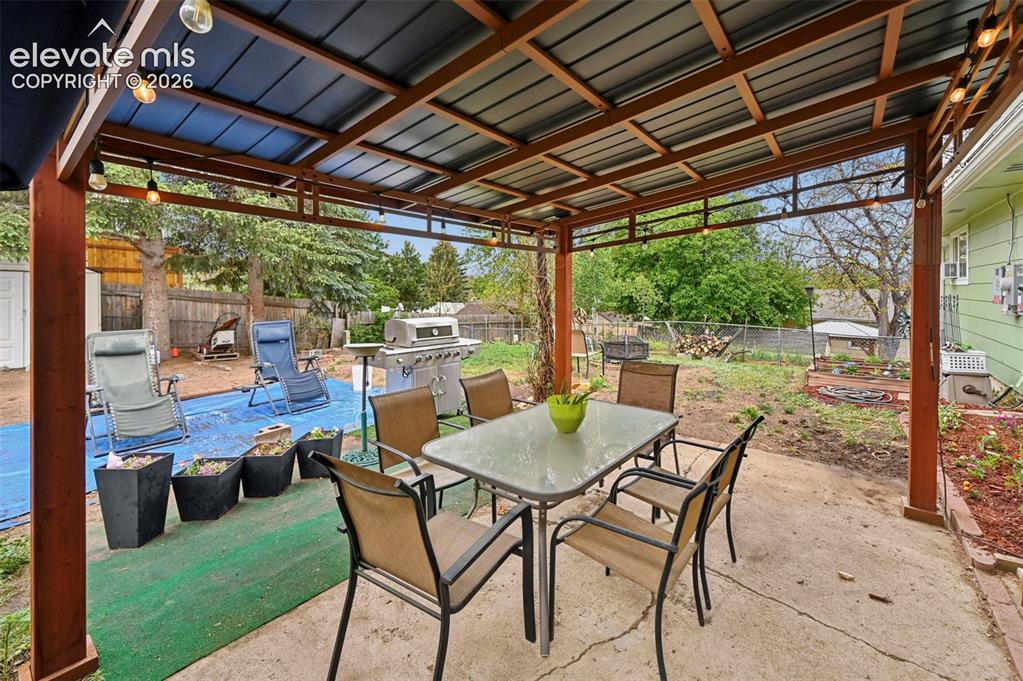 Image 29 of 33: Covered patio featuring a concrete slab and a Pergola that stays with the h