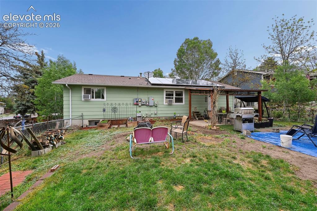Image 31 of 33: Expansive backyard featuring a partial chain-link fence, mature trees, and 