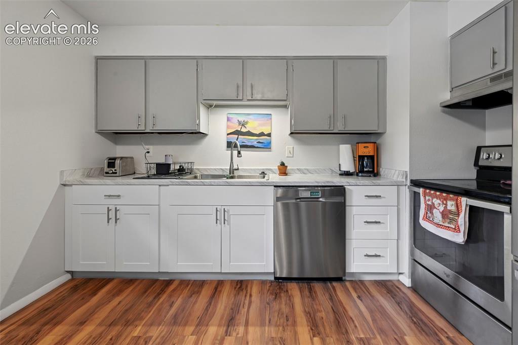 Image 9 of 33: Kitchen featuring wood-finish flooring and a stainless steel dishwasher