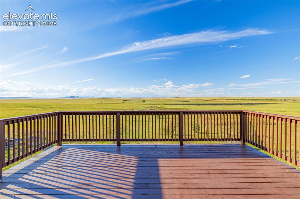 Image 10 of 50: Expansive outdoor deck with wood-finish flooring and full railing system, o