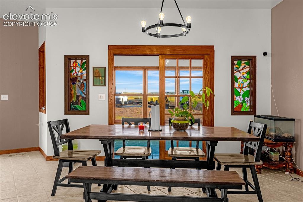 Image 13 of 50: Tiled flooring, wood-framed sliding glass doors, stained glass window featu