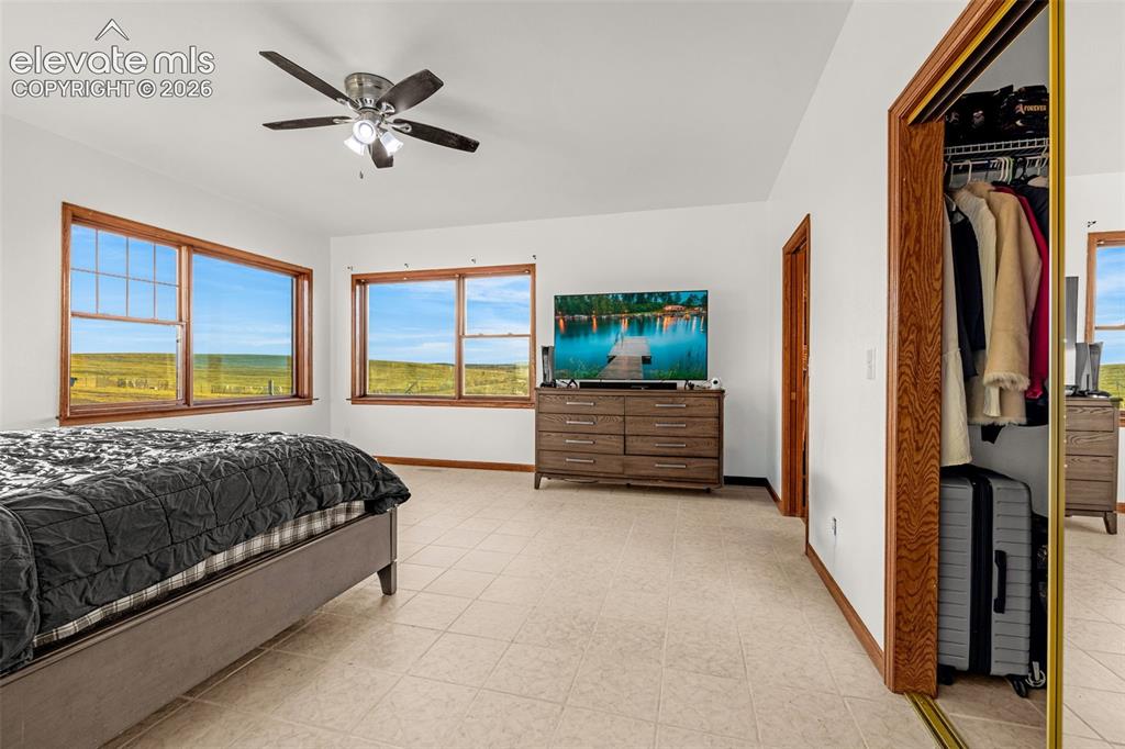 Image 18 of 50: White wall finishes, tile flooring, and wood-trim windows