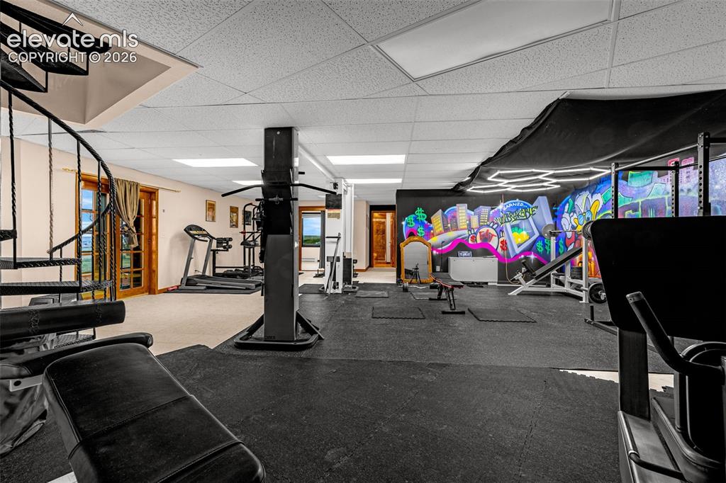 Image 28 of 50: Expansive space with rubberized flooring, a decorative wall mural, recessed