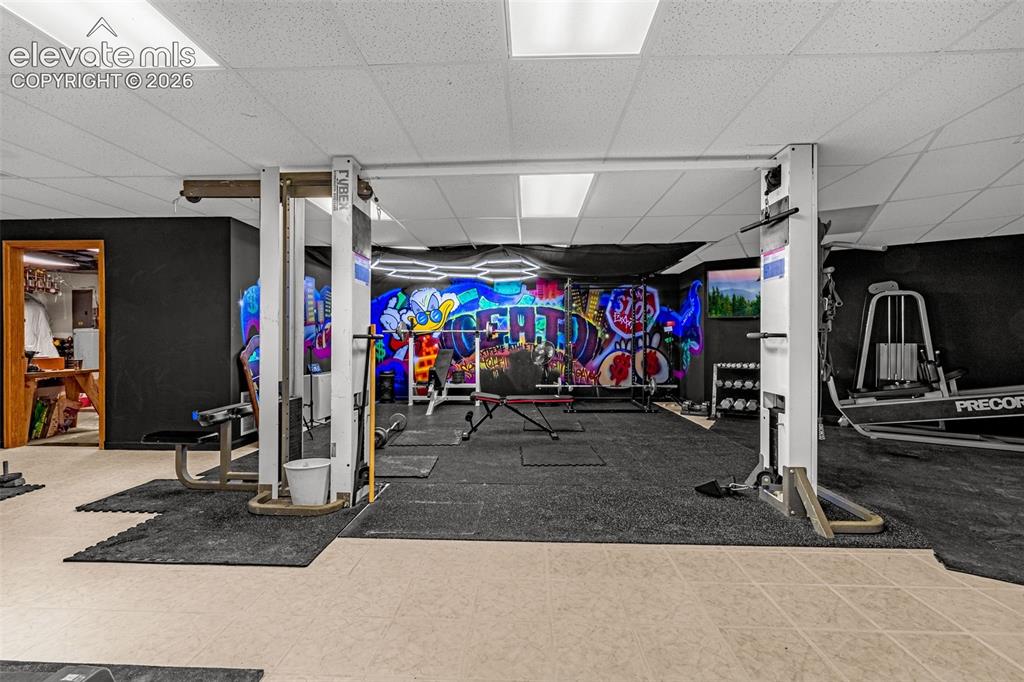 Image 30 of 50: Recreational space with mixed flooring, featuring a unique wall mural and r