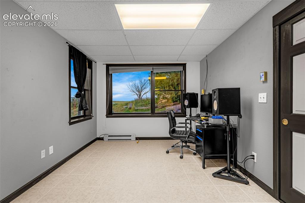 Image 31 of 50: Drop ceiling with integrated fluorescent lighting, neutral-toned flooring, 