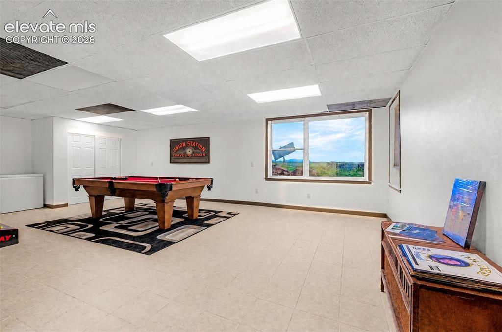 Image 33 of 50: Recessed lighting, light-toned flooring, and expansive windows with wood-fi