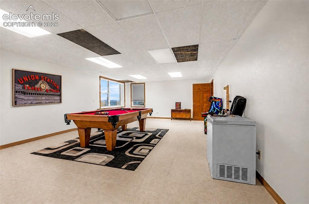 Image 34 of 50: Expansive recreational room featuring large windows, light-colored flooring