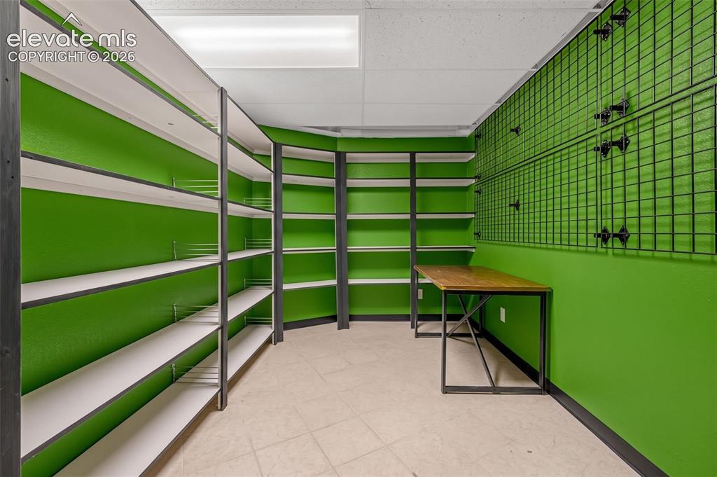 Image 35 of 50: Integrated shelving units, grid wall storage, tile flooring, and a built-in