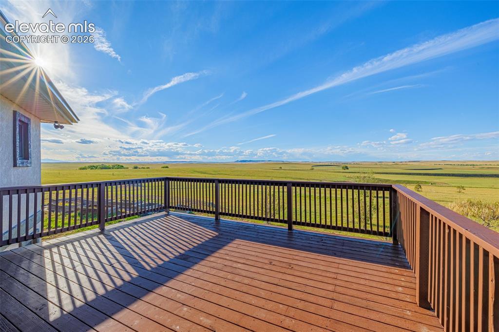Image 38 of 50: Expansive outdoor deck with wood-finish flooring and a full railing system,