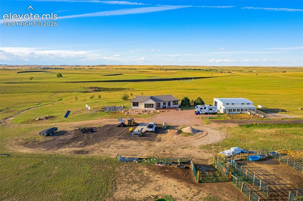 Image 7 of 50: Expansive rural property featuring a primary residence with a gray roof, a