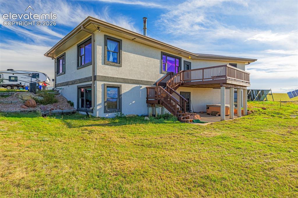 Image 9 of 50: Two-story exterior with a stucco finish, elevated deck with railing, exteri