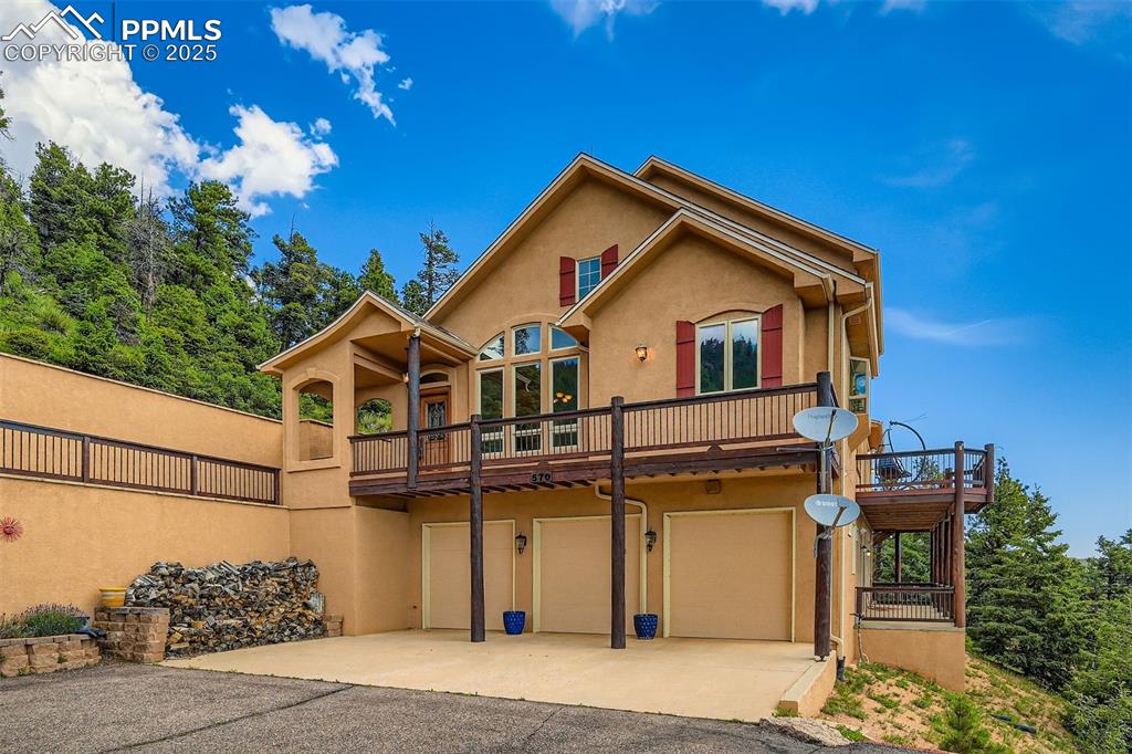 Caption: View of front of property featuring stucco siding, concrete driveway, and a 3-car garage
