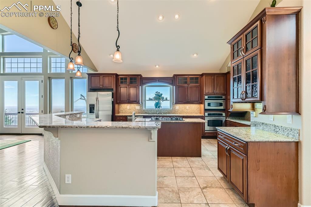 Image 11 of 27: Kitchen with a spacious island, stainless steel appliances, vaulted ceiling