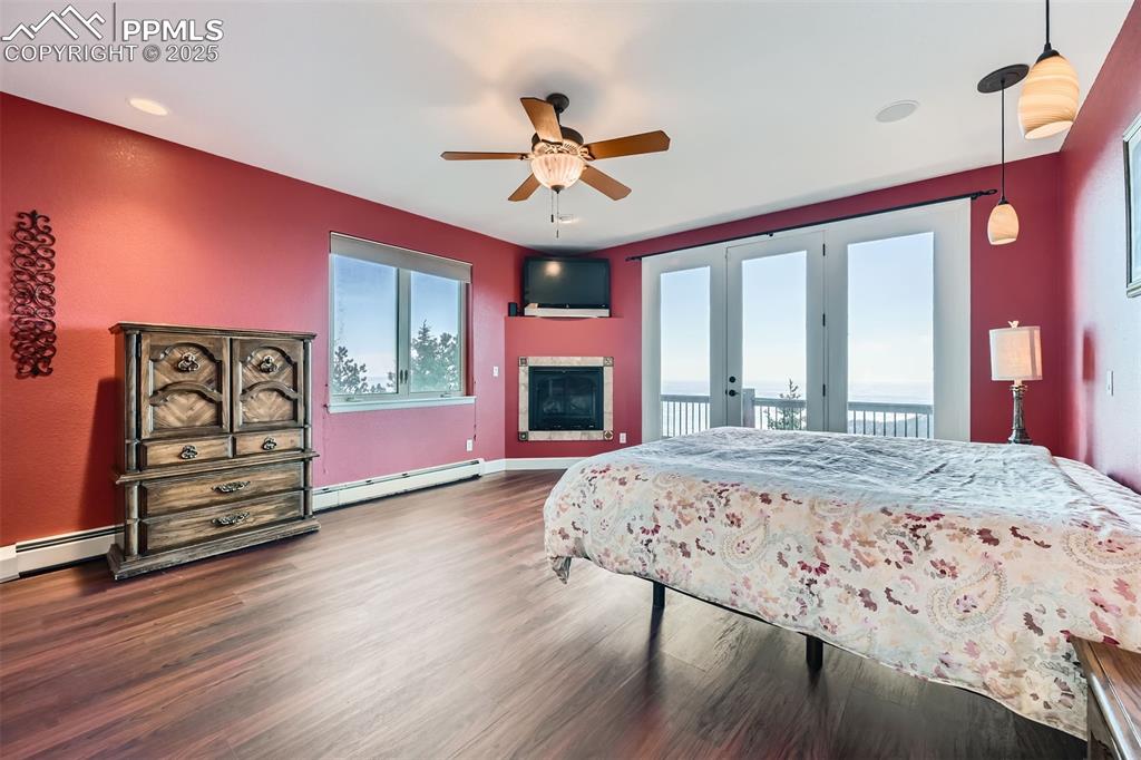 Image 13 of 27: Master bedroom with access to deck, and baseboard heating unit, and a ceili