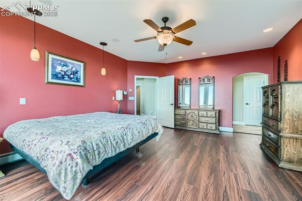 Image 14 of 27: Master bedroom with arched walkways, ceiling fan, and recessed lighting