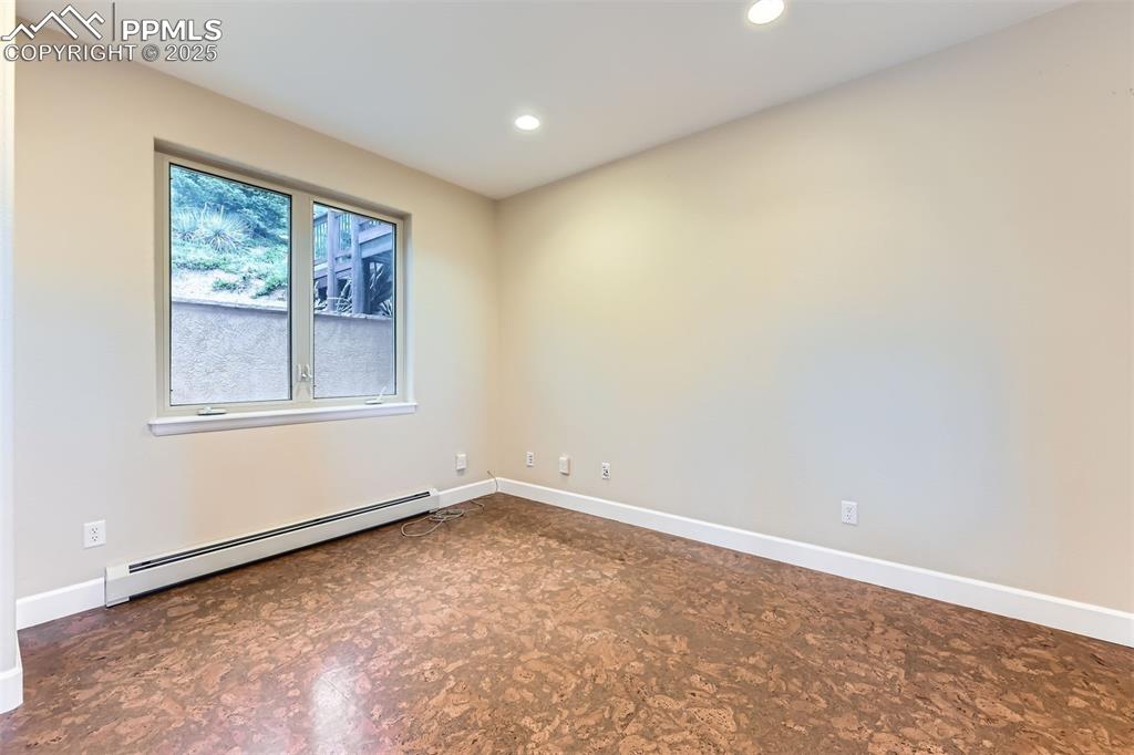 Image 17 of 27: Office with cork floors, a baseboard radiator and recessed lighting