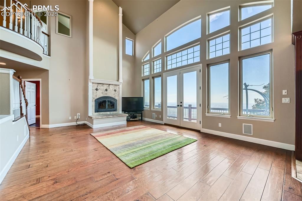 Image 6 of 27: Unfurnished living room with high vaulted ceiling, hardwood / wood-style fl