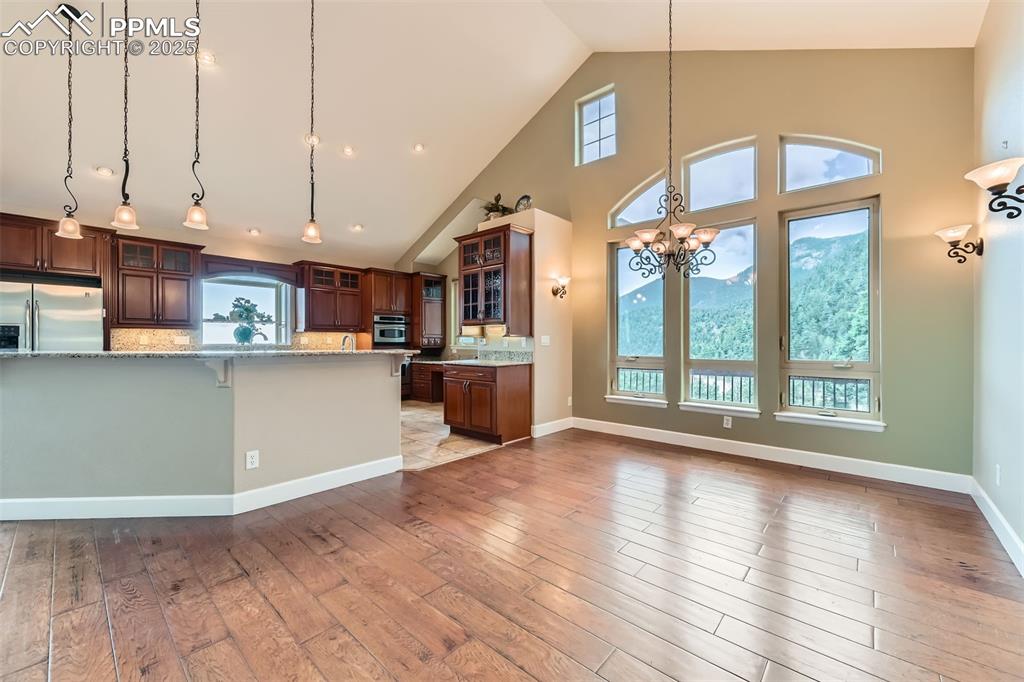 Image 8 of 27: Kitchen with stainless steel appliances, a chandelier, pendant lighting, wo