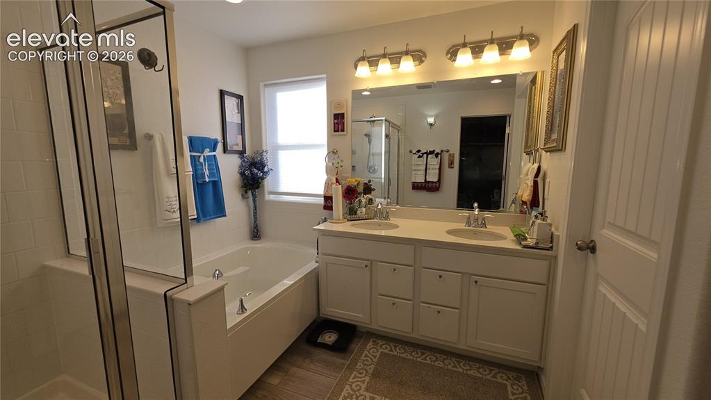 Image 28 of 48: Dual vanity with undermount sinks, a built-in jetted tub, separate glass-en