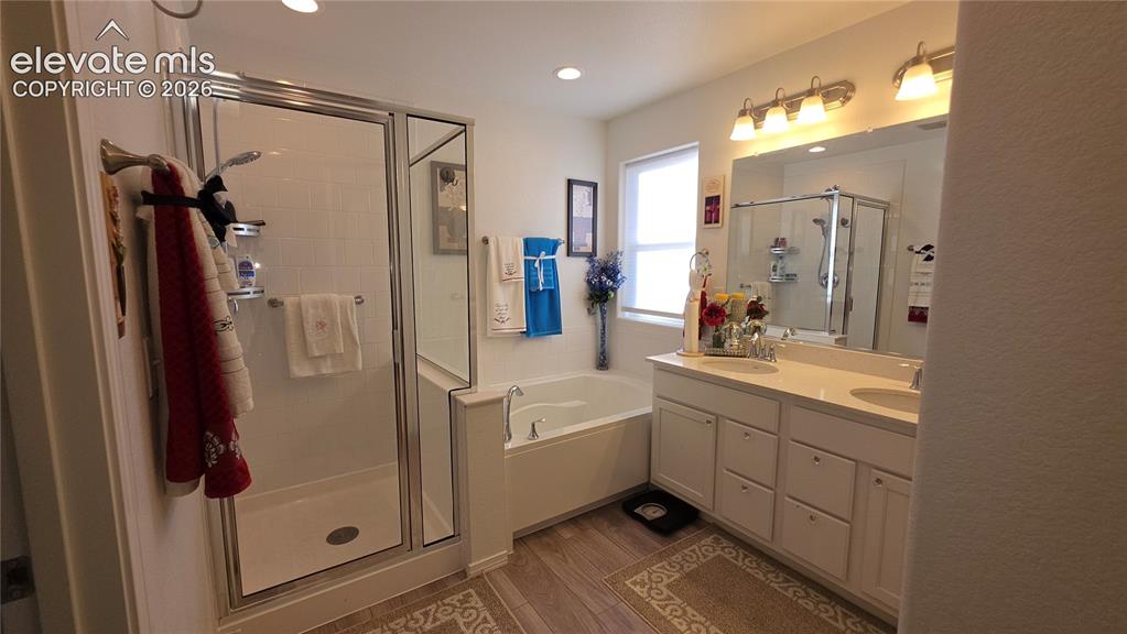 Image 29 of 48: Dual vanity with white cabinetry, built-in soaking tub, glass-enclosed show