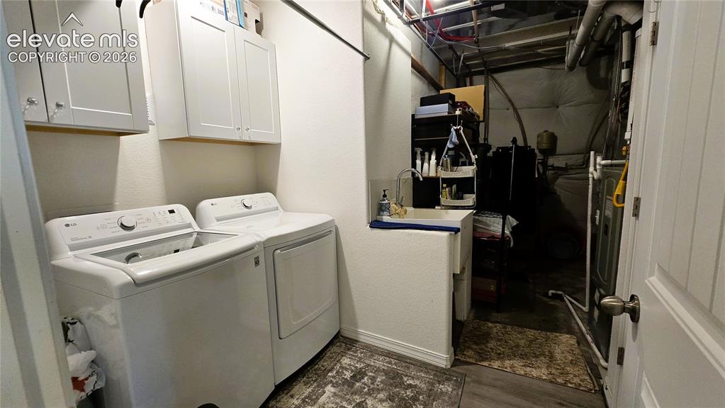 Image 31 of 48: Dedicated laundry room featuring side-by-side washer and dryer, ample cabin
