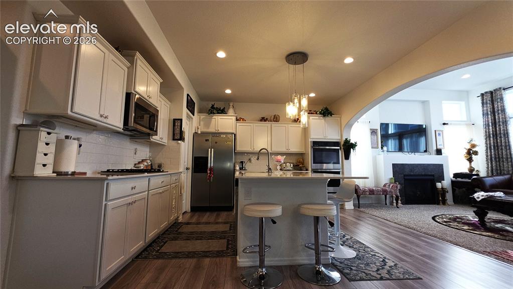 Image 9 of 48: Kitchen featuring white cabinetry, stainless steel appliances, a kitchen is