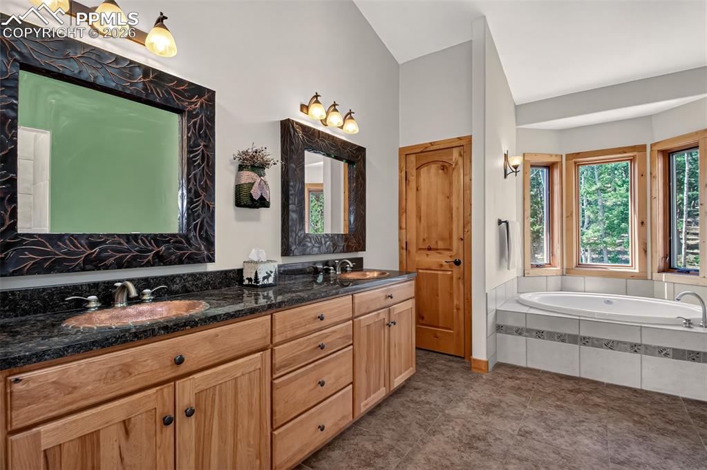 Image 29 of 48: Primary bedroom on the upper level with knotty pecan flooring, built in she