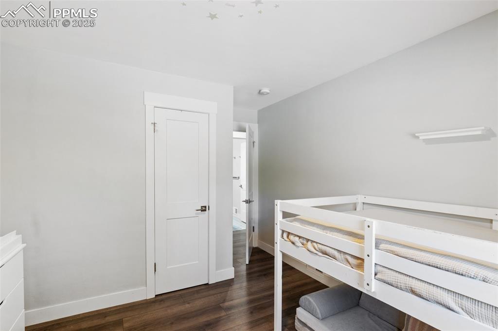 Image 17 of 31: Bedroom featuring dark wood-style flooring and baseboards