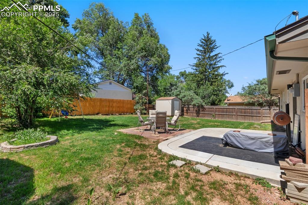 Image 23 of 31: Fenced backyard featuring a patio and a shed