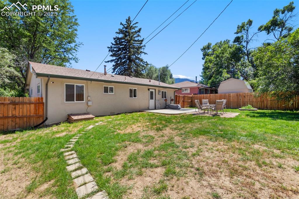 Image 25 of 31: Rear view of house with a patio, a fenced backyard, and stucco siding