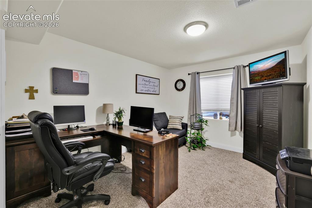 Image 31 of 50: Basement level bedroom used as office