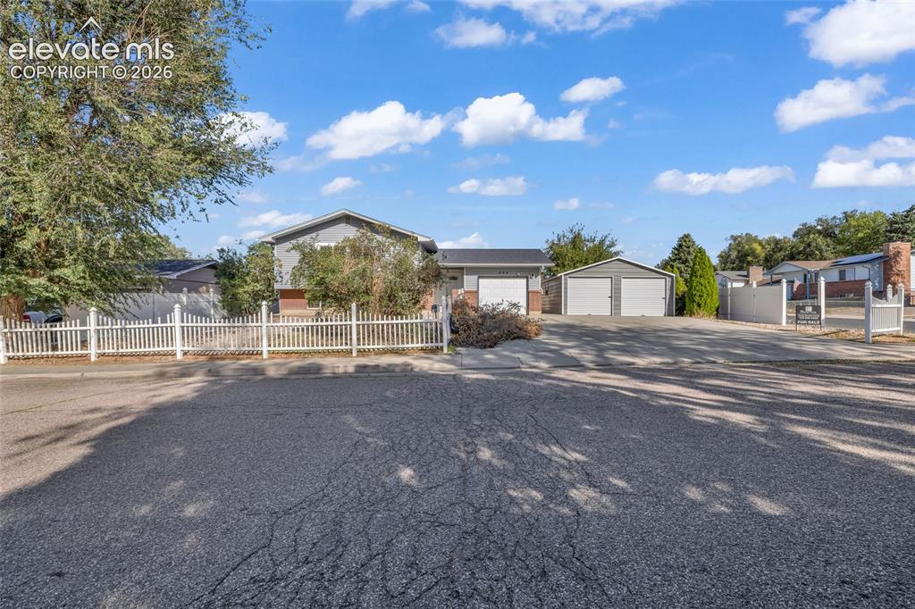Image 1 of 25: Split-level exterior with a two-car attached garage and an additional detac