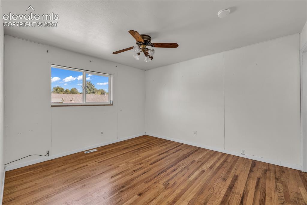 Image 15 of 25: Hardwood flooring, white walls, and a multi-pane window
