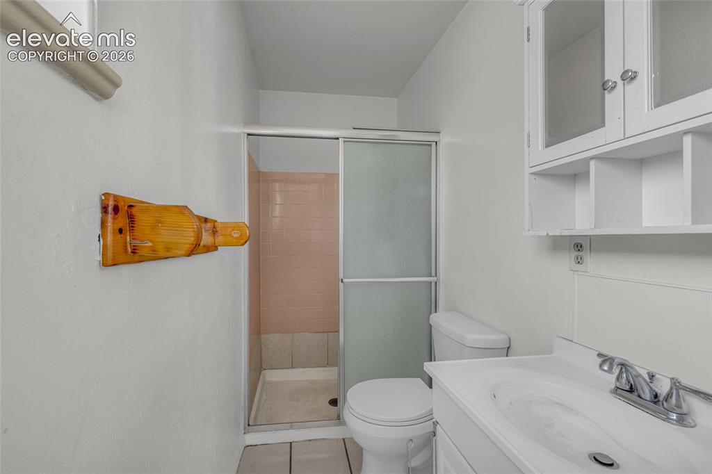 Image 16 of 25: White vanity with integrated sink, chrome faucet, and white cabinetry with 