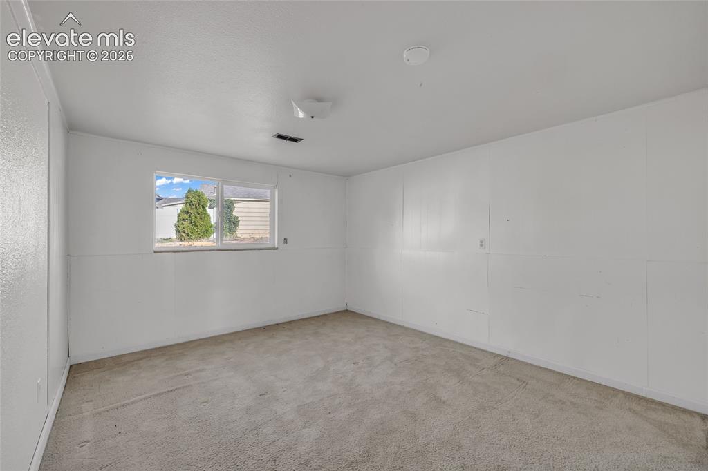 Image 21 of 25: Wall-to-wall carpeting and a single window