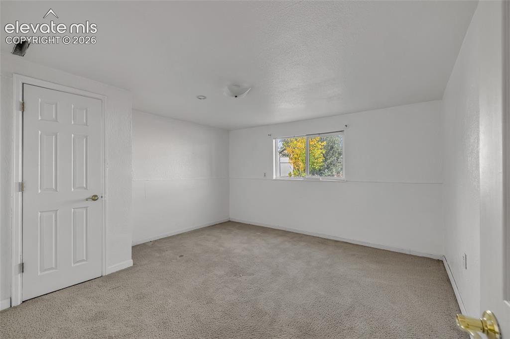 Image 22 of 25: Neutral wall color, carpeted flooring, a window offering natural light, and