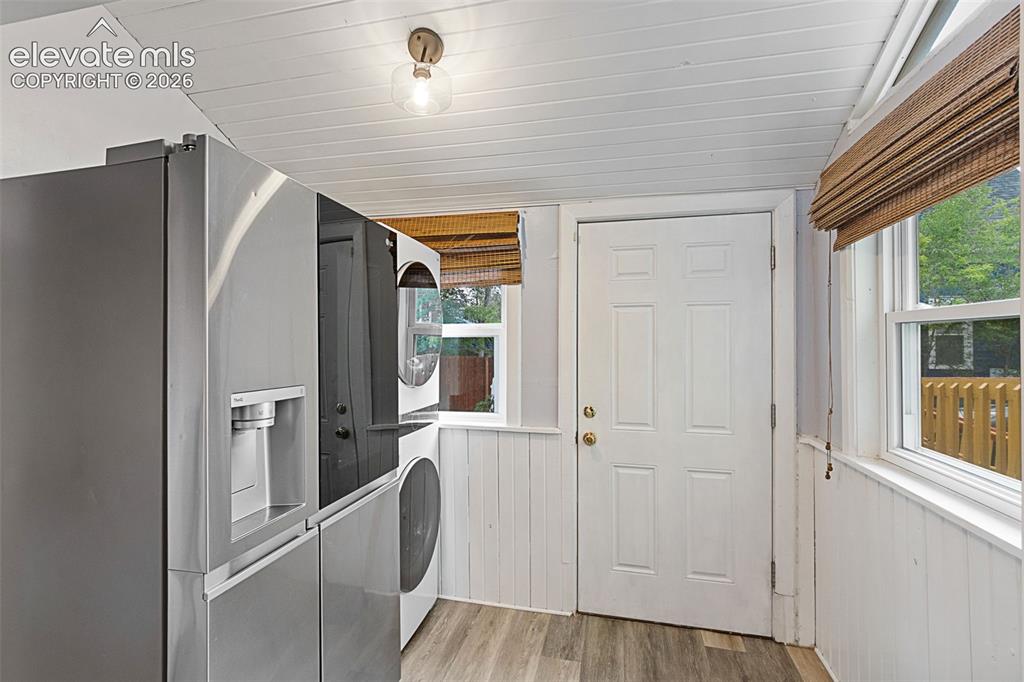 Image 18 of 38: Additional kitchen and laundry space with walk-out to the backyard.